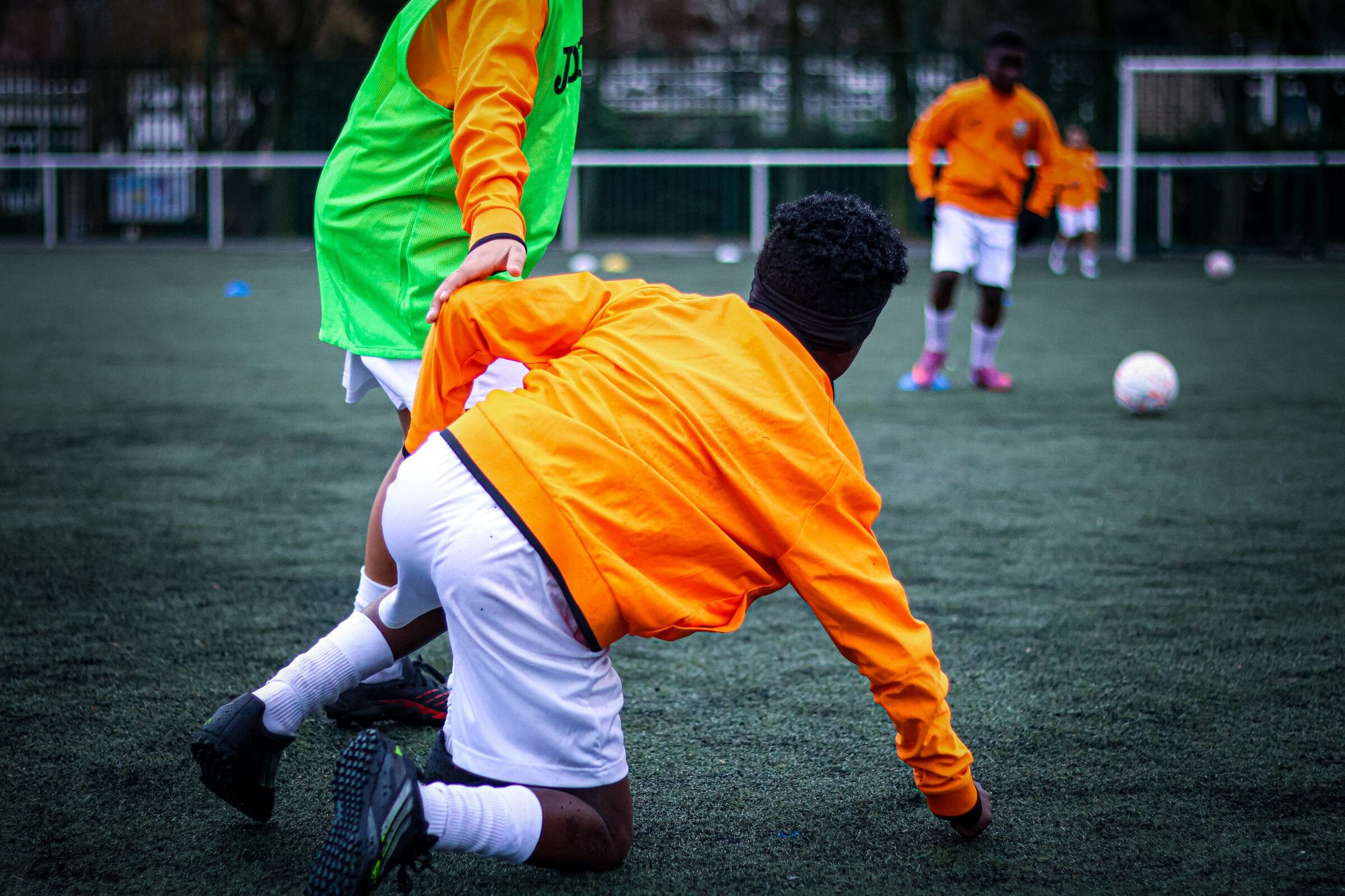 Duel pour le ballon entre deux jeunes joueurs AB Football Académie, terrain synthétique